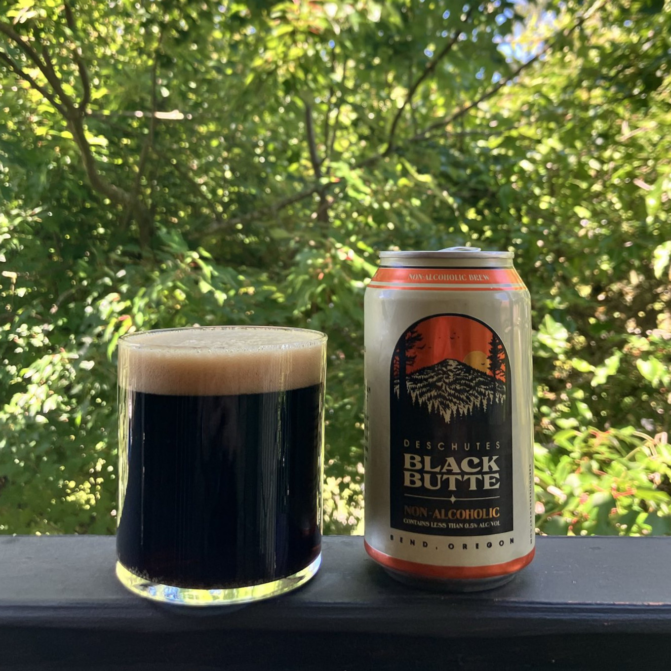 Deschutes Brewing&rsquo;s Black Butte Porter in a 12 ounce can, poured into a minimalist lowball glass, on a balcony railing